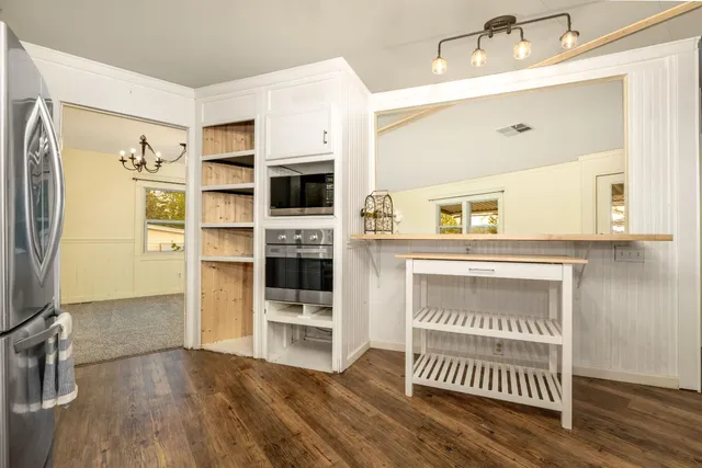 a view of a kitchen with furniture and wooden floor