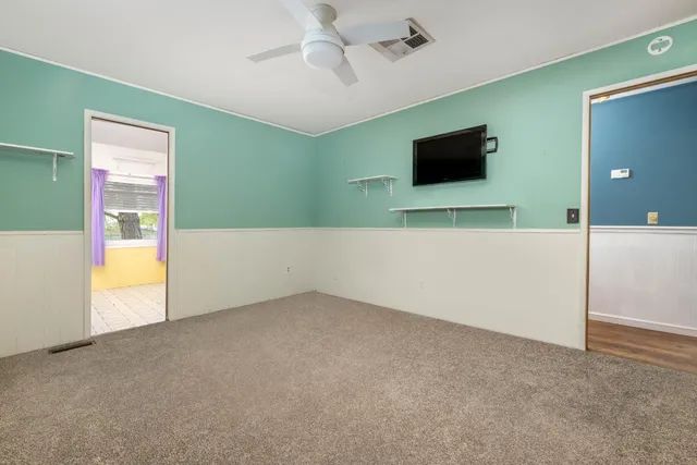 a view of an empty room with a fireplace and a flat tv screen