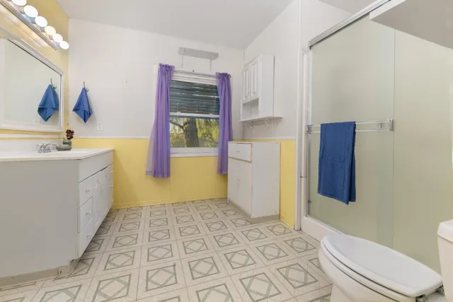 a bathroom with a sink mirror vanity and toilet