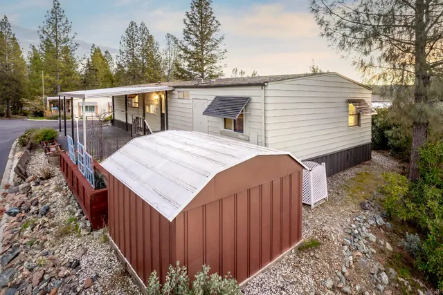 a view of a house with backyard and trees