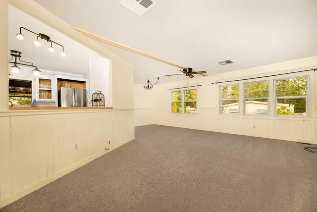a view of a big room with windows and chandelier