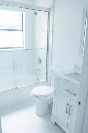 a white toilet sitting next to a shower