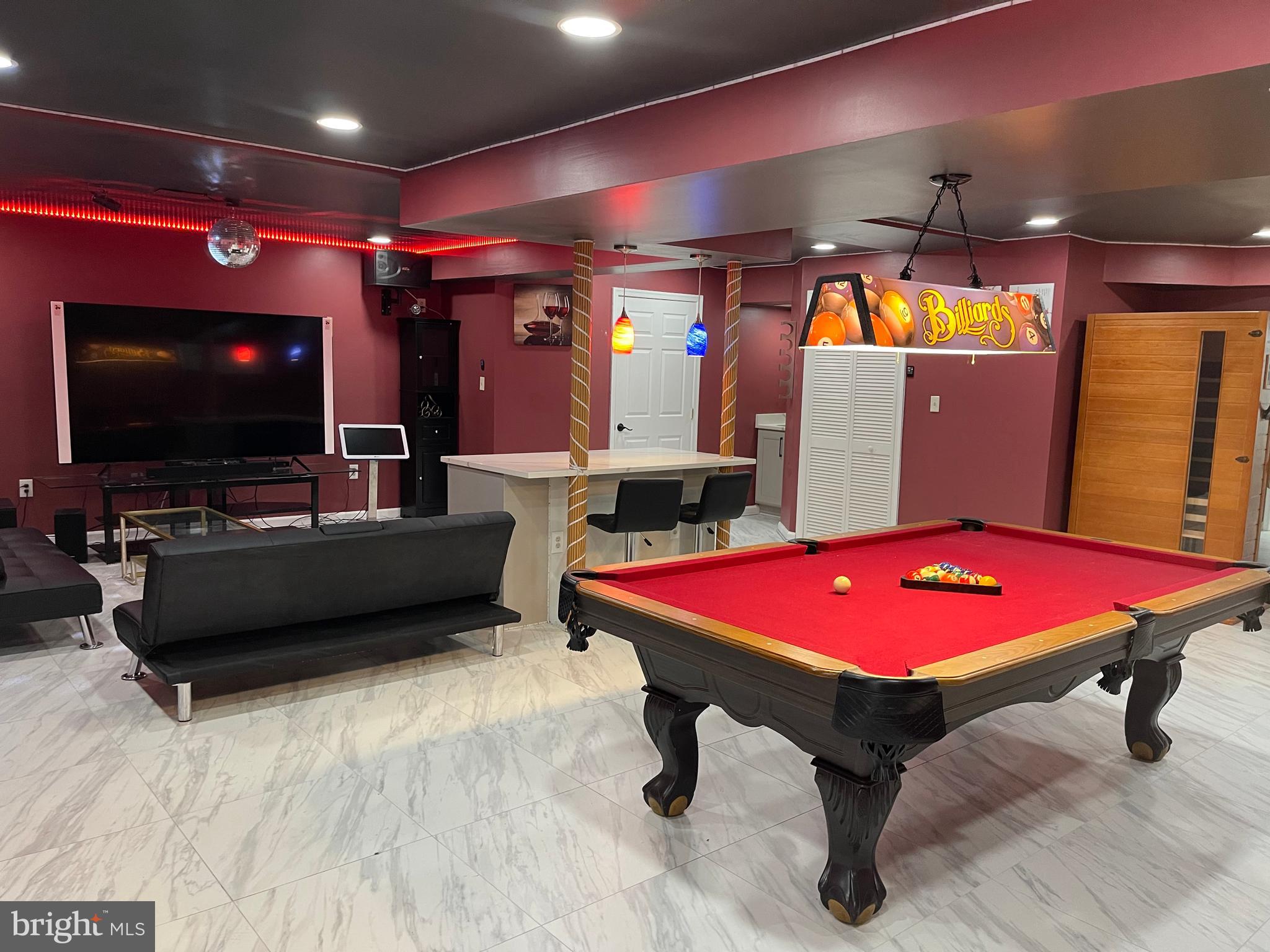 a living room with a flat screen tv and pool table