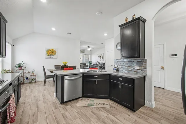 a kitchen with a sink cabinets and wooden floor