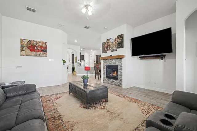 a living room with furniture a flat screen tv and a fireplace