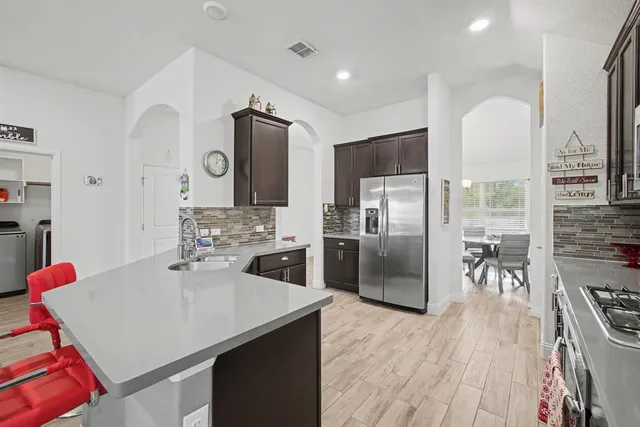 a kitchen with stainless steel appliances a refrigerator and a stove top oven