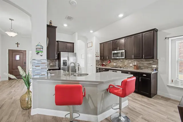 a kitchen with stainless steel appliances granite countertop a stove refrigerator sink and microwave