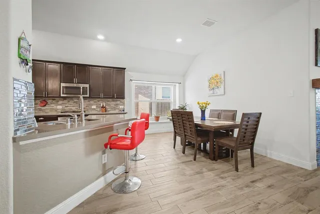 a view of a dining room with furniture a kitchen and chandelier