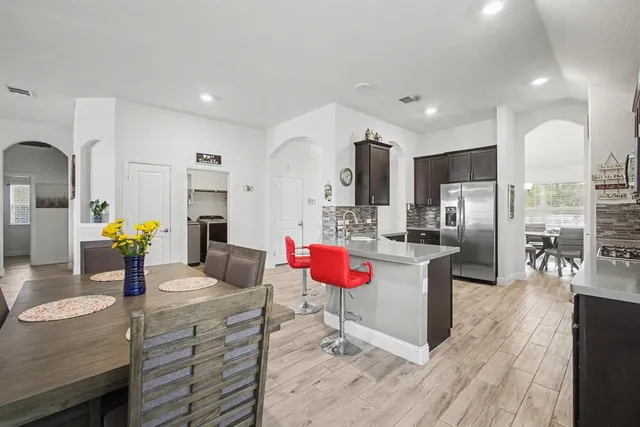 a kitchen with stainless steel appliances kitchen island granite countertop a refrigerator and a stove