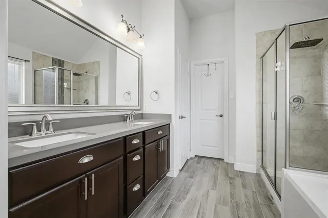 a spacious bathroom with a granite countertop sink toilet a mirror and shower