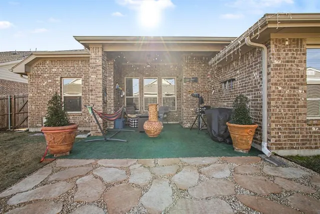 a view of a patio with couple of chairs and potted plants