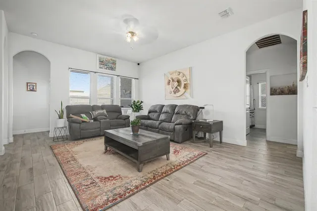 a living room with furniture and a wooden floor