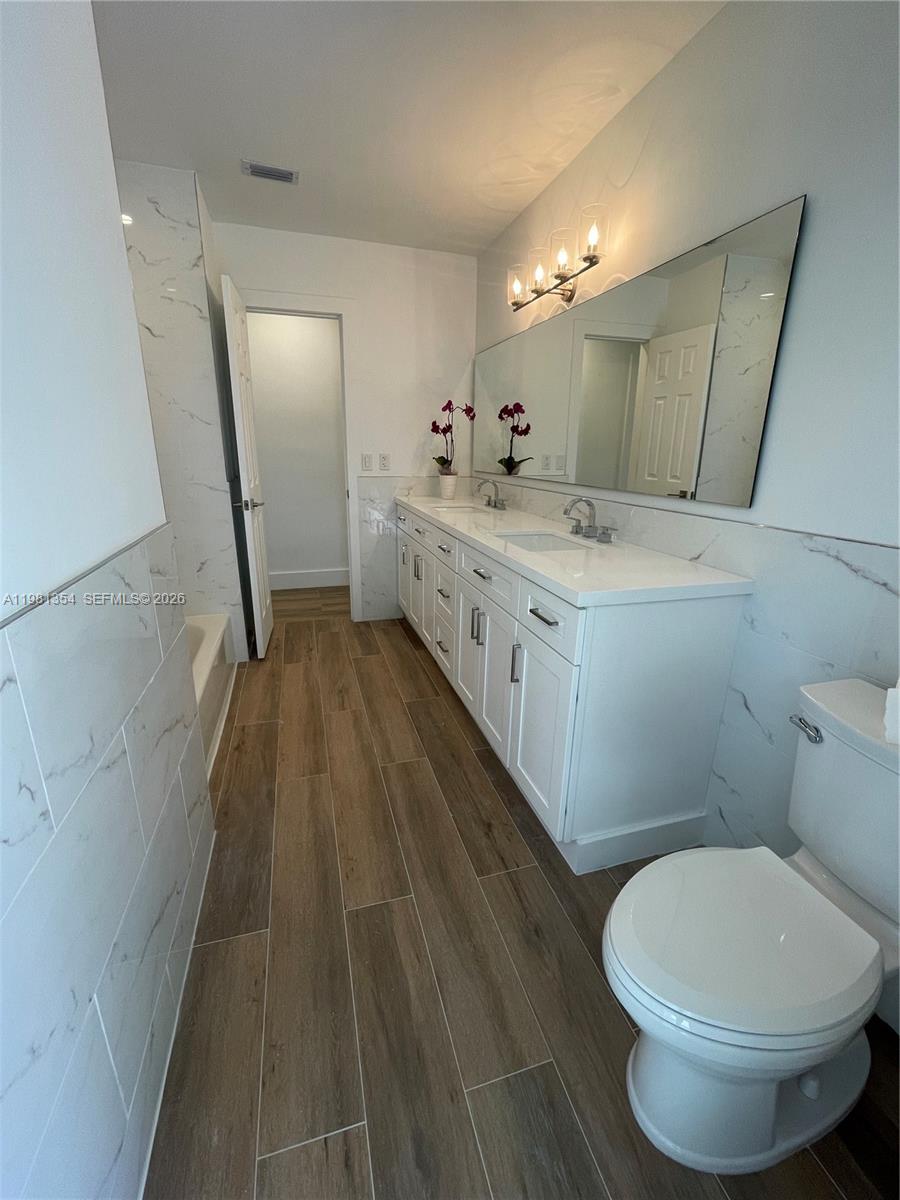 10343 Southwest 114th Street Miami, FL 33176 - Photo 13 of 25 a bathroom with a double vanity sink toilet and mirror