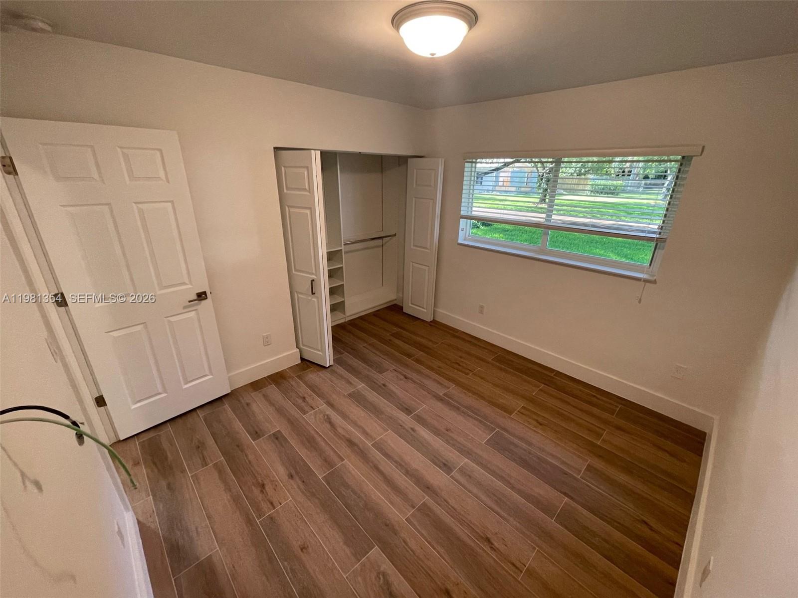 10343 Southwest 114th Street Miami, FL 33176 - Photo 14 of 25 a view of an empty room with wooden floor and a window