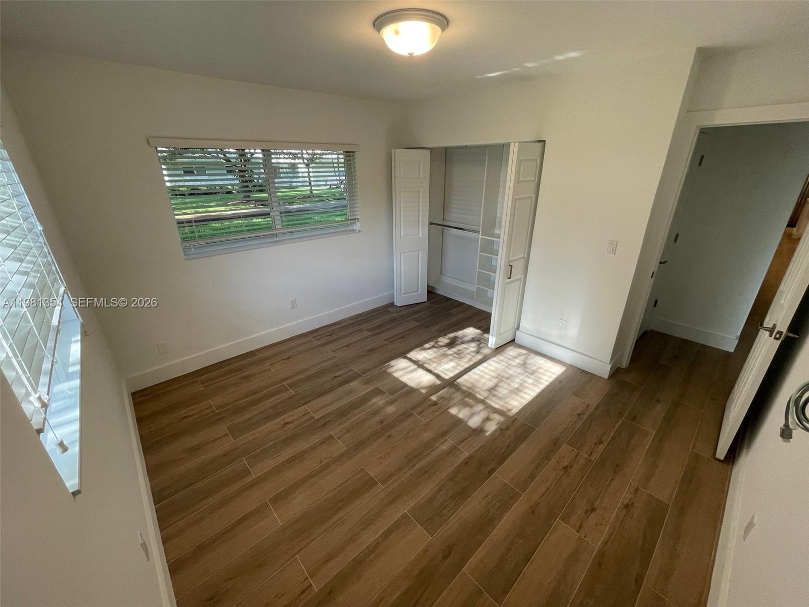 10343 Southwest 114th Street Miami, FL 33176 - Photo 15 of 25 a view of an empty room with wooden floor and a window
