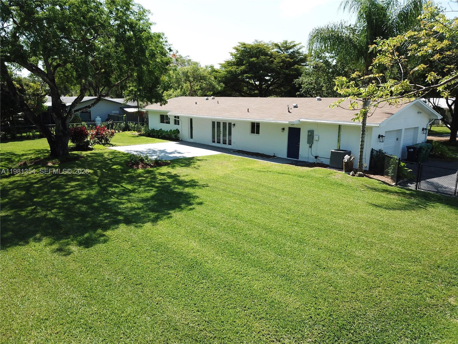 10343 Southwest 114th Street Miami, FL 33176 - Photo 21 of 25 a view of a house with a big yard and large trees