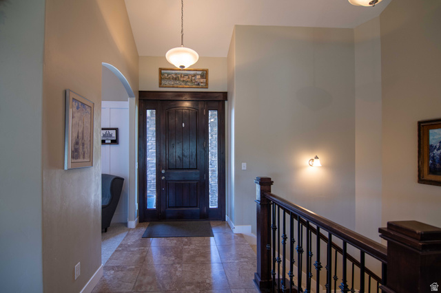 646 East 1400th Street North Mapleton, UT 84664 - Photo 9 of 78 Grand entryway featuring a dark wood door with sidelight windows, tile flooring, and a decorative archway