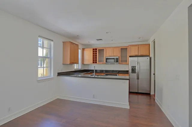 a kitchen with stainless steel appliances granite countertop a refrigerator a stove a sink and a microwave