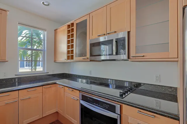 a kitchen with granite countertop a sink a stove and cabinets