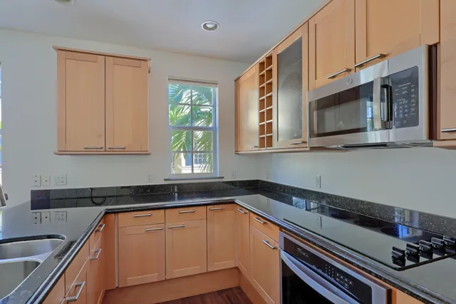 a kitchen with granite countertop a sink cabinets and window