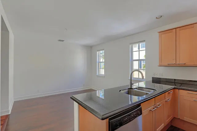 a kitchen with stainless steel appliances granite countertop a sink a stove and a refrigerator