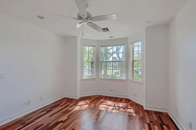 a view of empty room with wooden floor