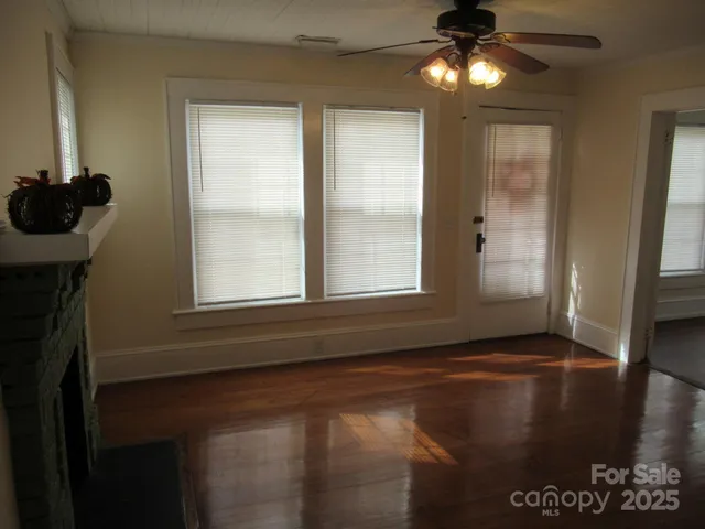 a view of empty room with window and chandelier fan