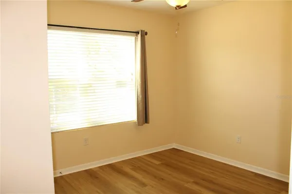 a view of a small space with wooden floor and a window