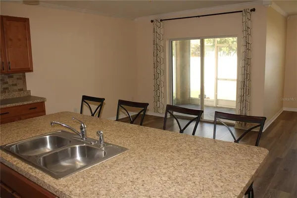 a kitchen with a sink a table and chairs in it