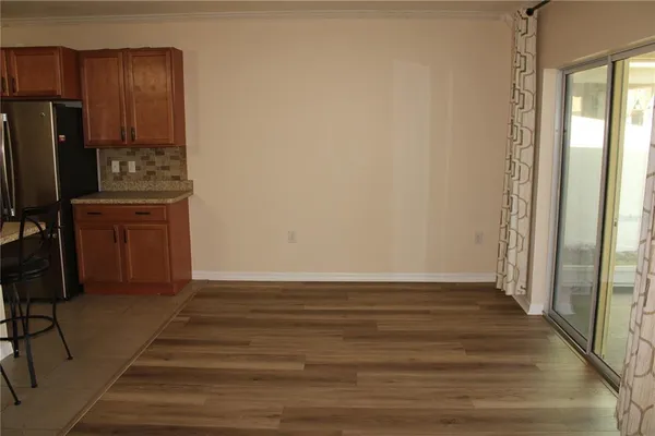 a view of a kitchen with wooden floor and electronic appliances