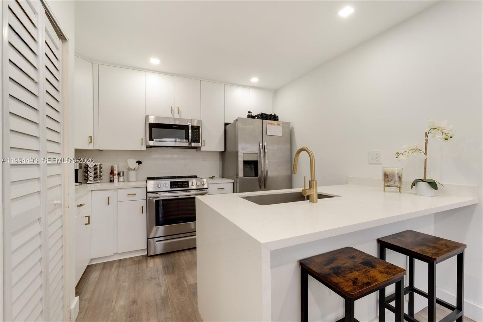 13235 Southwest 114th Terrace Miami, FL 33186 - Photo 12 of 26 a kitchen with stainless steel appliances a stove a sink a microwave and a refrigerator