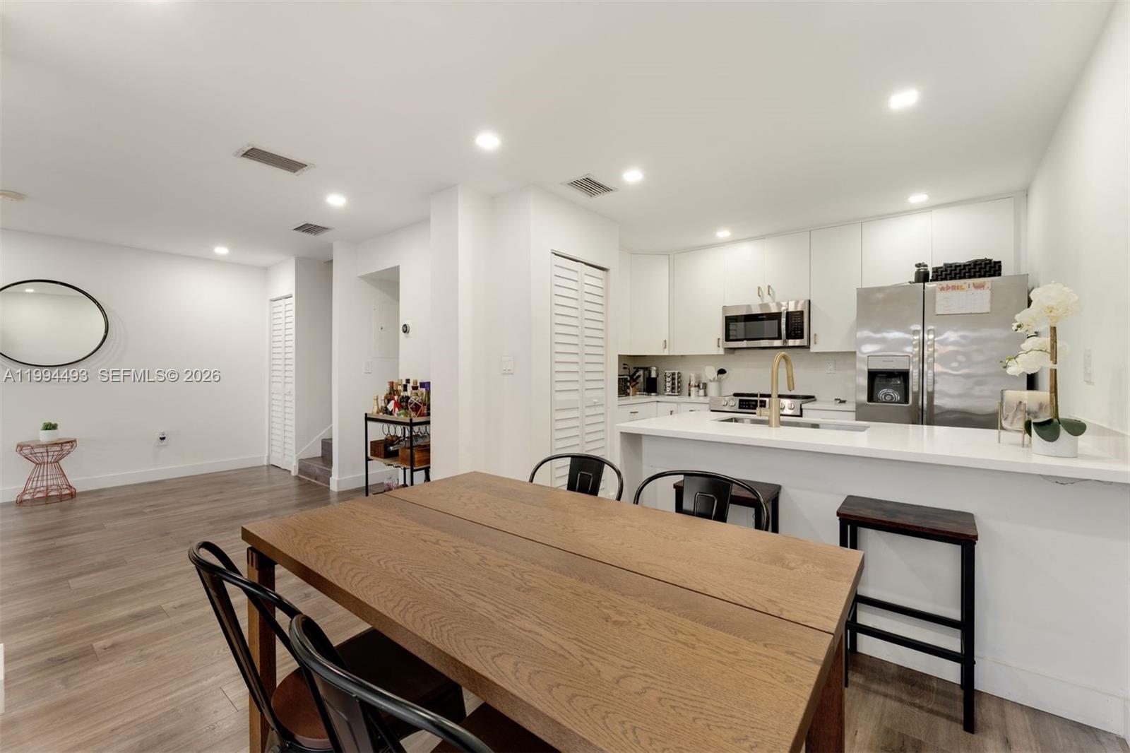 13235 Southwest 114th Terrace Miami, FL 33186 - Photo 14 of 26 a kitchen with kitchen island a stove a sink a dining table and chairs
