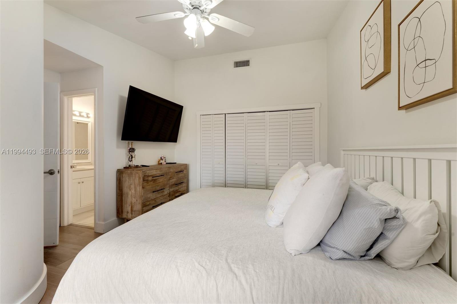 13235 Southwest 114th Terrace Miami, FL 33186 - Photo 20 of 26 a bedroom with a bed and a flat screen tv