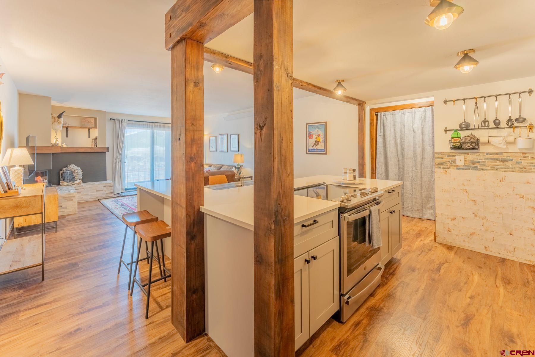 72 Hunter Hill Road, Unit I103 Crested Butte, CO 81225 - Photo 11 of 35 a kitchen with stainless steel appliances granite countertop a refrigerator a stove and a wooden floors