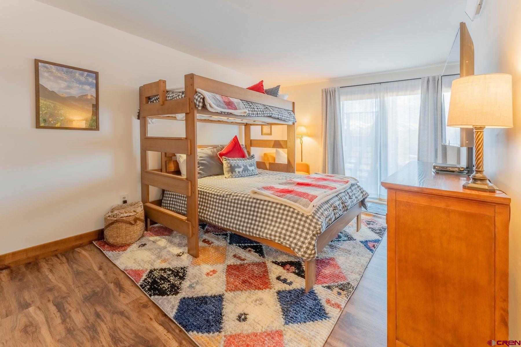 72 Hunter Hill Road, Unit I103 Crested Butte, CO 81225 - Photo 22 of 35 a bedroom with a bed and wooden floor