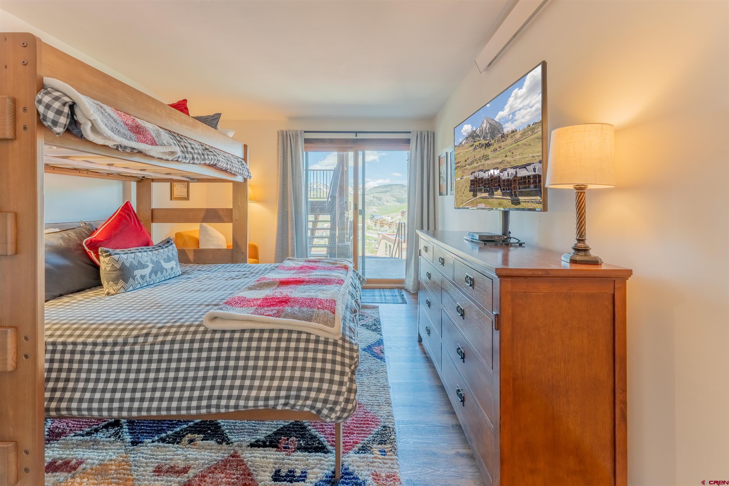 72 Hunter Hill Road, Unit I103 Crested Butte, CO 81225 - Photo 23 of 35 a bedroom with furniture and a flat screen tv
