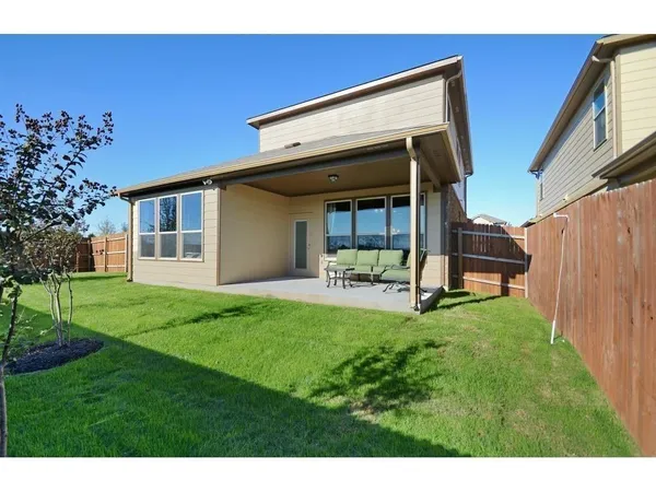 a view of backyard of house with deck and outdoor seating