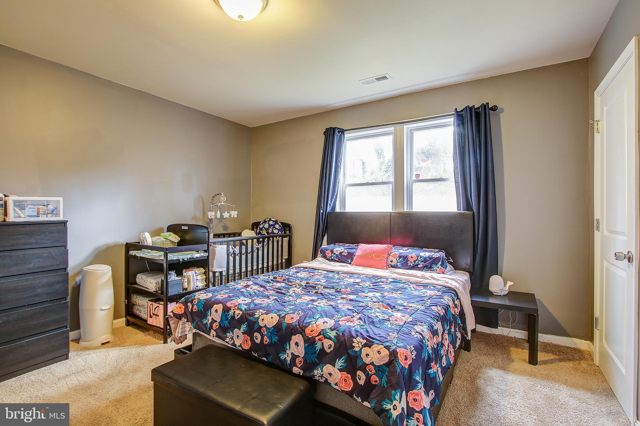7641 Muncy Road Landover, MD 20785 - Photo 22 of 31 a bedroom with a bed table chair and a window