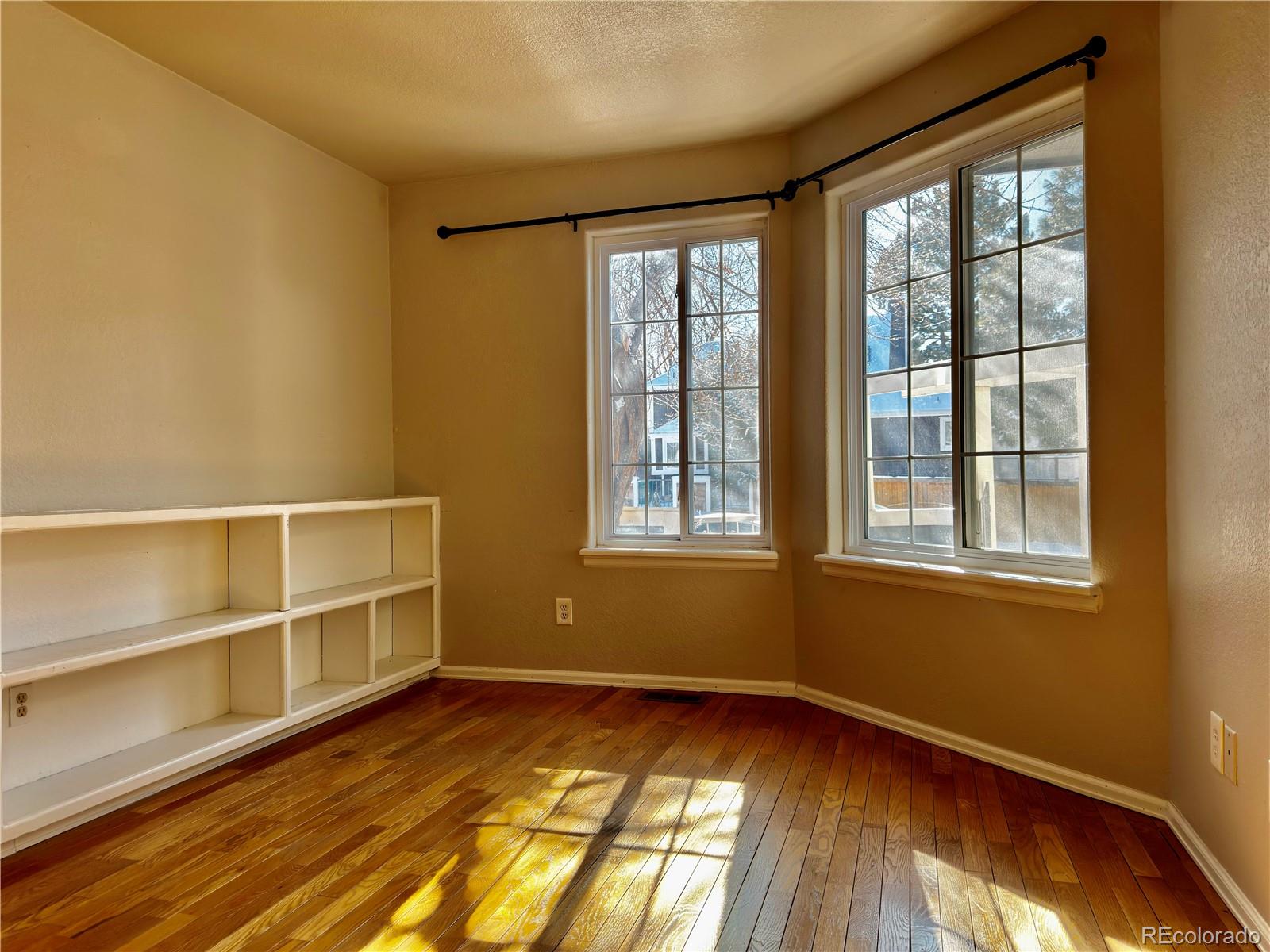 3615 South Flanders Street Aurora, CO 80013 - Photo 11 of 30 a view of an empty room with wooden floor and a window