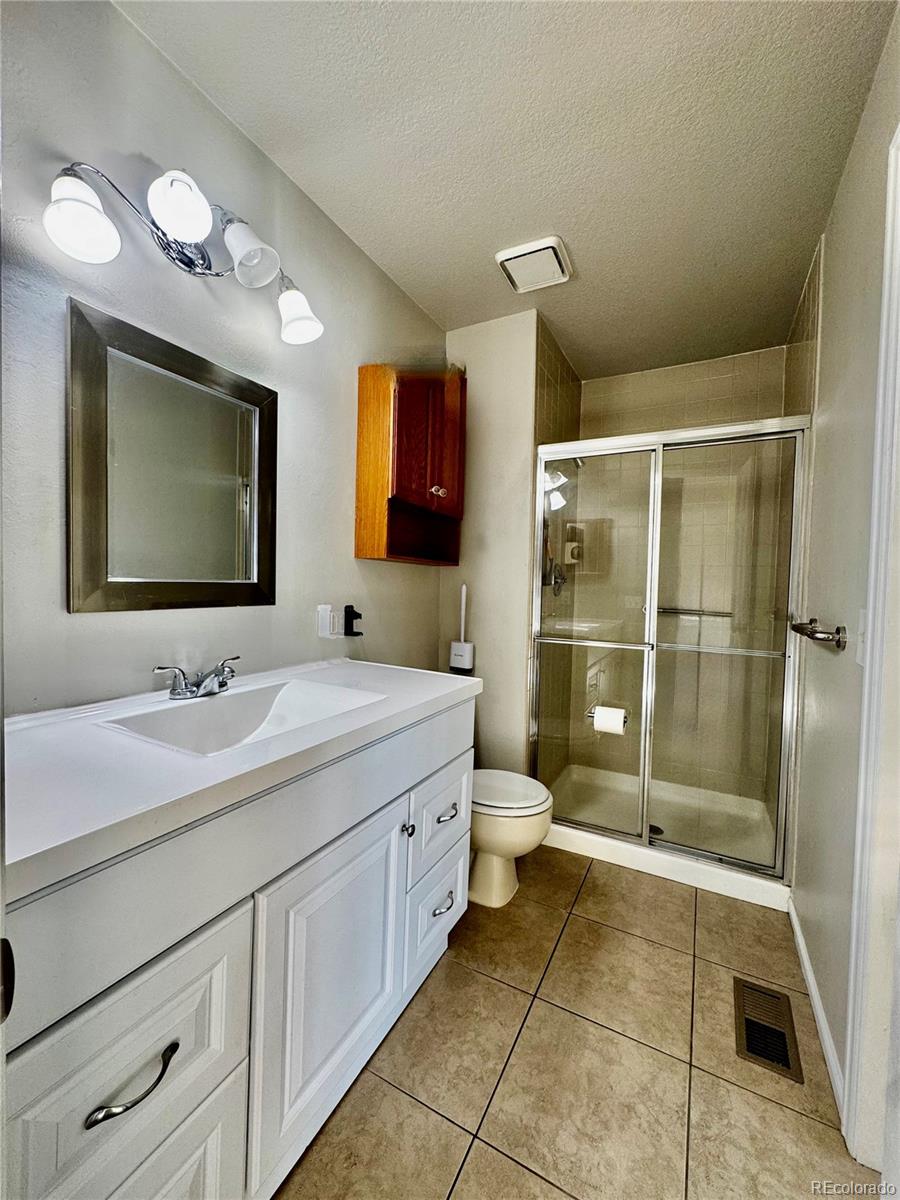 3615 South Flanders Street Aurora, CO 80013 - Photo 12 of 30 a bathroom with a toilet sink double vanity and mirror