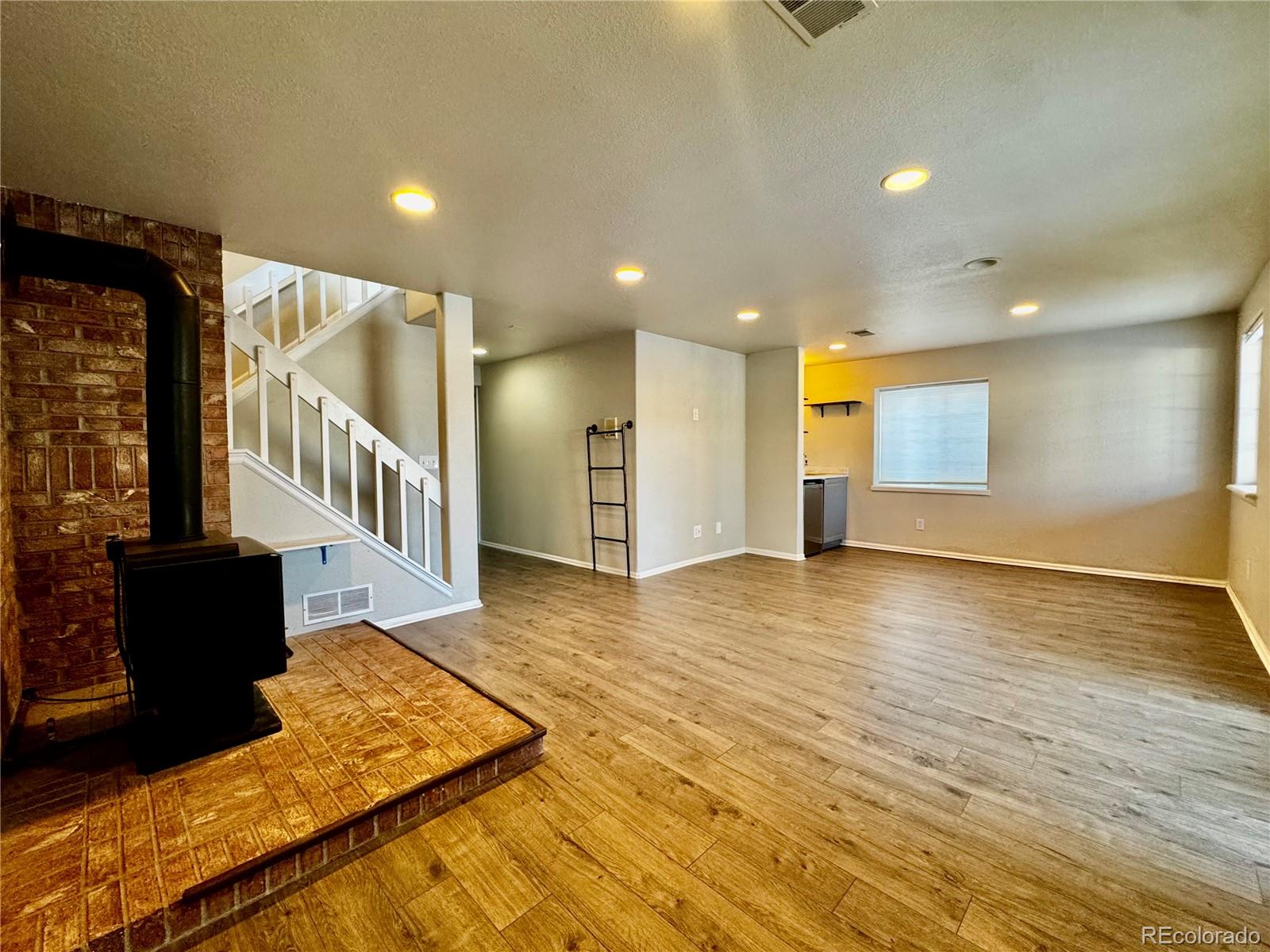 3615 South Flanders Street Aurora, CO 80013 - Photo 16 of 30 a view of a livingroom with wooden floor and stairs
