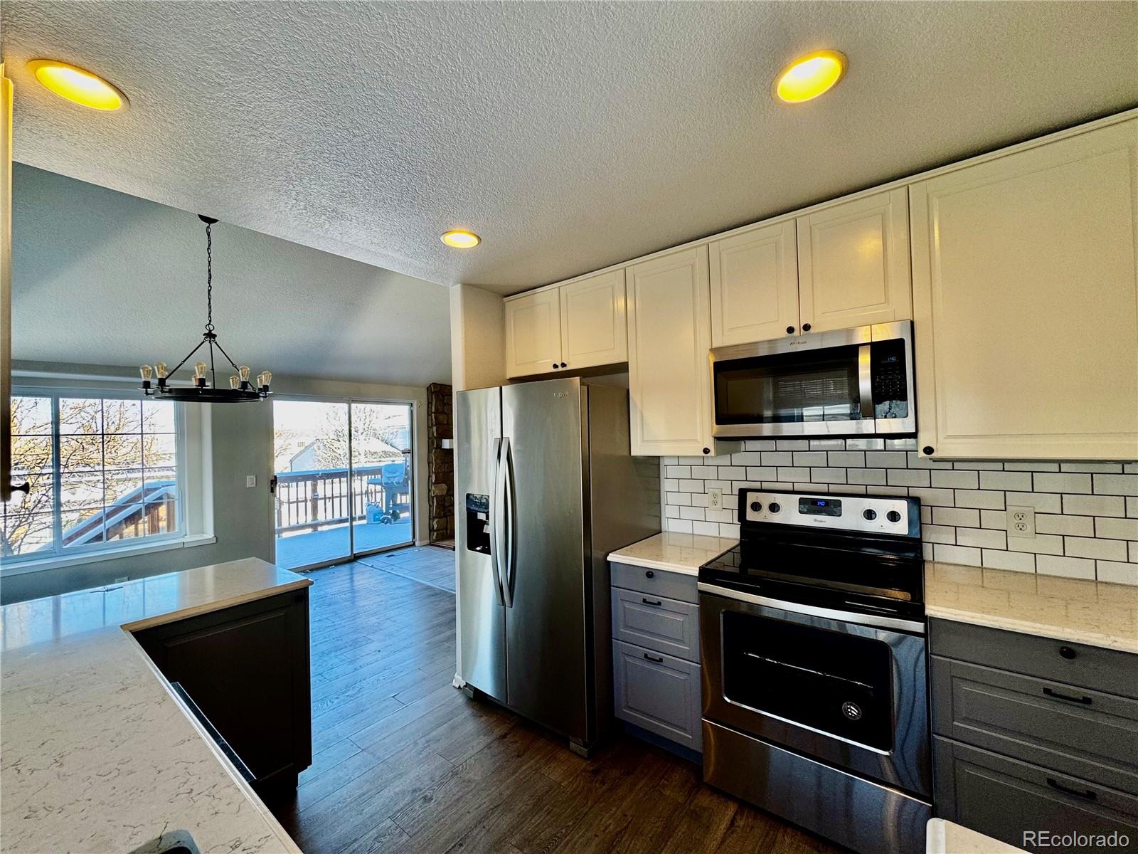 3615 South Flanders Street Aurora, CO 80013 - Photo 8 of 30 a kitchen with stainless steel appliances a stove a refrigerator and a microwave