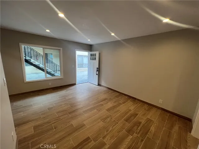 an empty room with wooden floor and window