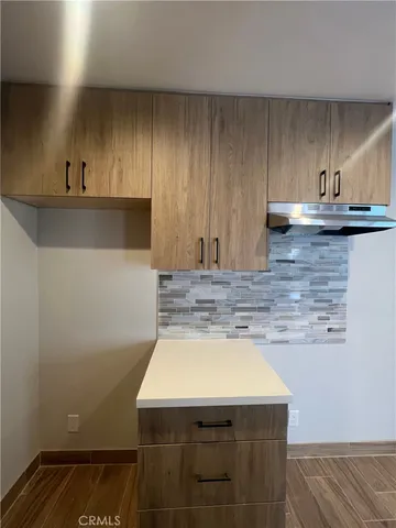 a kitchen with a sink cabinets and wooden floor