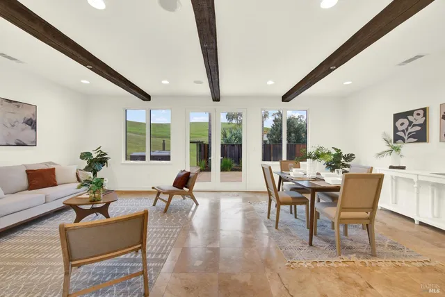a dining room with furniture potted plants and a large window
