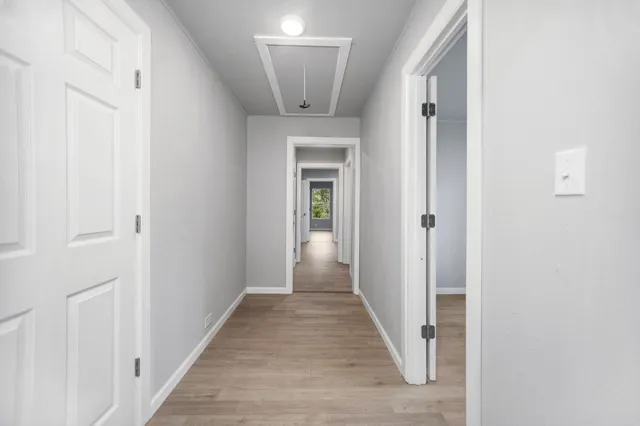 a view of a hallway with wooden floor