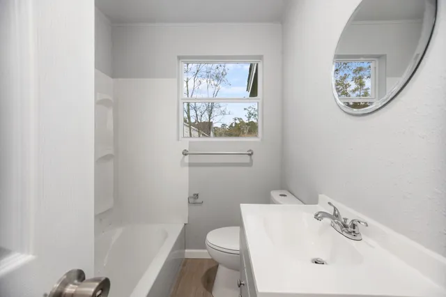 a white toilet sitting next to a bath tub