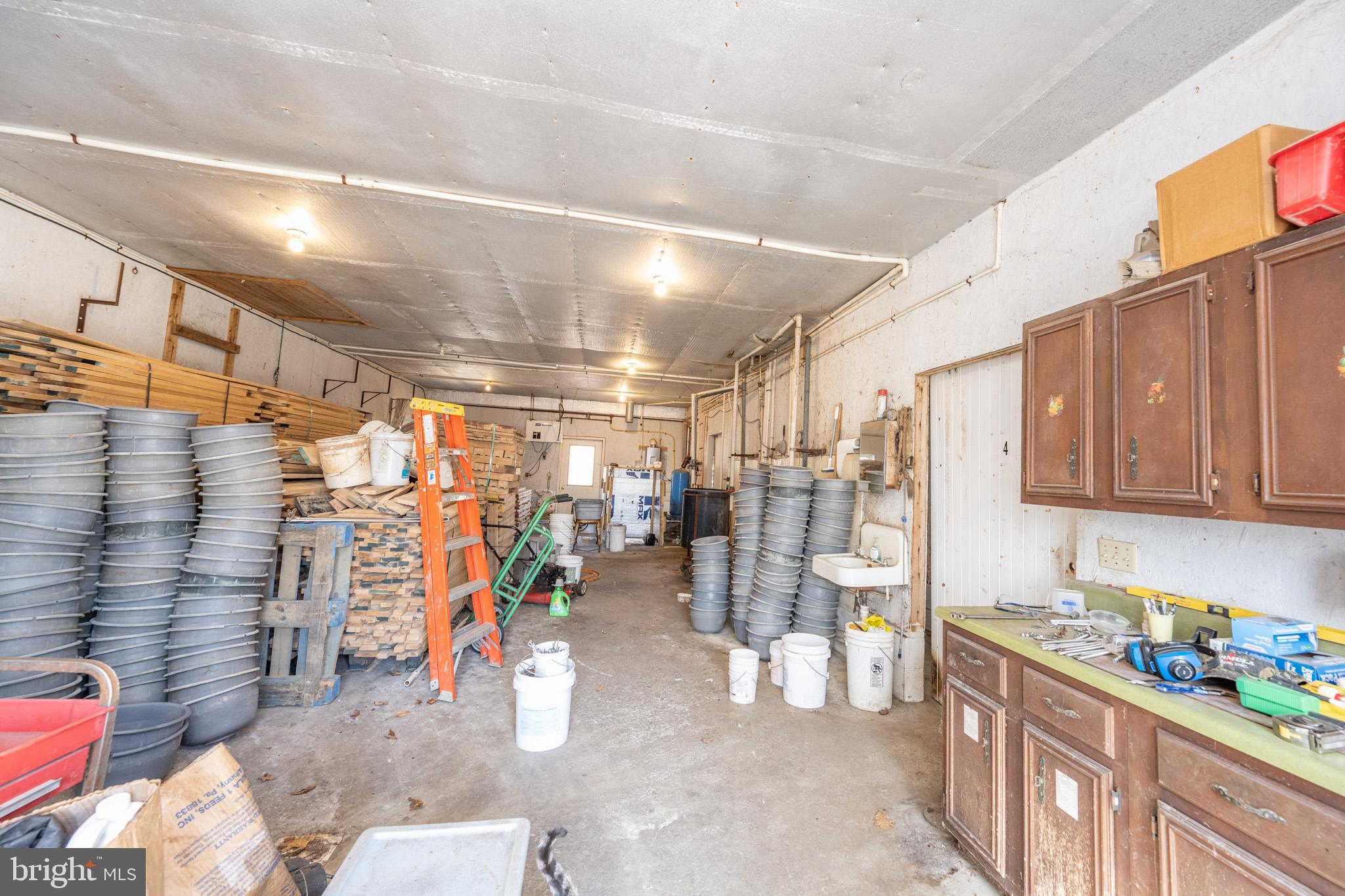 616 Crab Run Road Grantsville, MD 21536 - Photo 24 of 43 a view of a storage room with water heater and racks