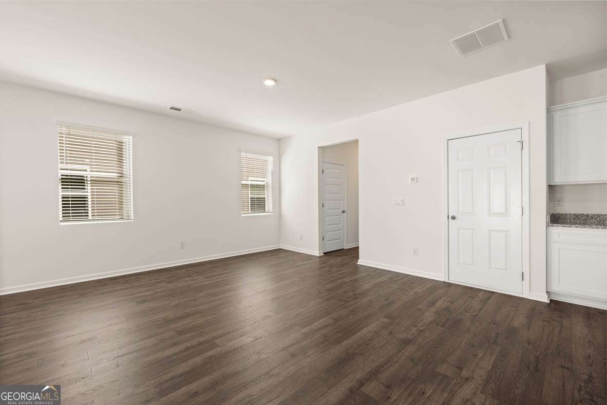 6010 Knickerbocker Street, Unit 135 Mableton, GA 30126 - Photo 9 of 17 an empty room with wooden floor and windows