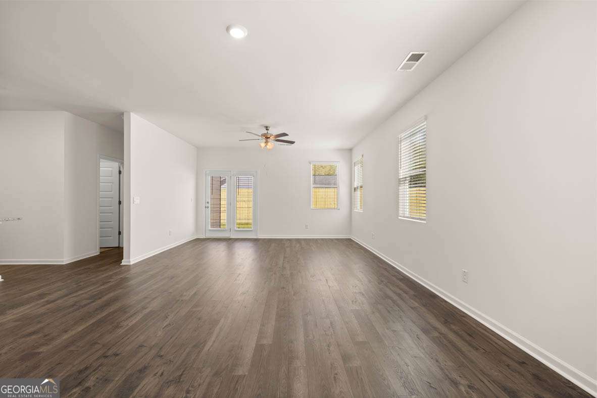 6010 Knickerbocker Street, Unit 135 Mableton, GA 30126 - Photo 10 of 17 an empty room with wooden floor and windows